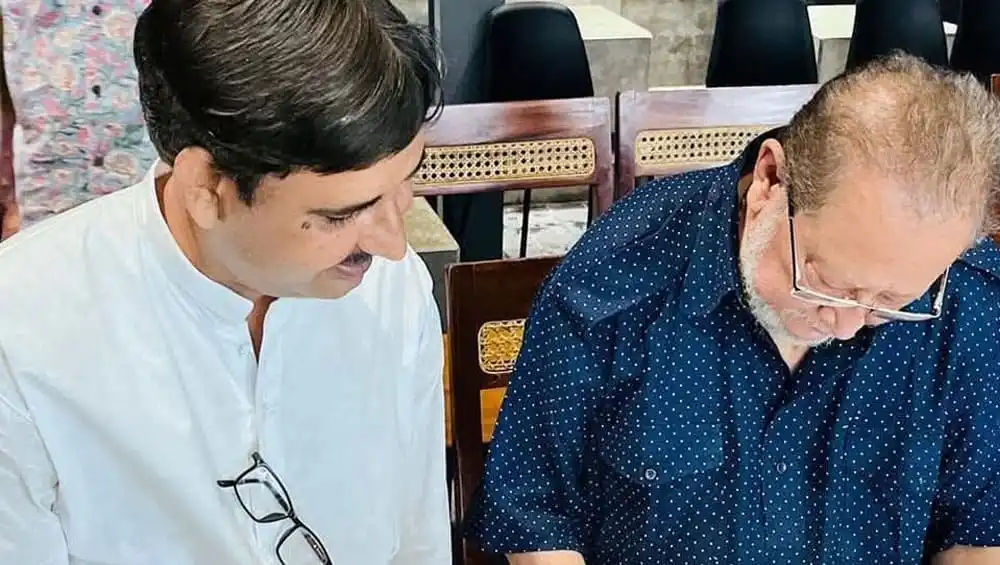 দুই ব্যক্তি আলোচনা করছে, একটি কাগজের উপর নজর দিচ্ছে. Channel i News - চ্যানেল আই নিউজ