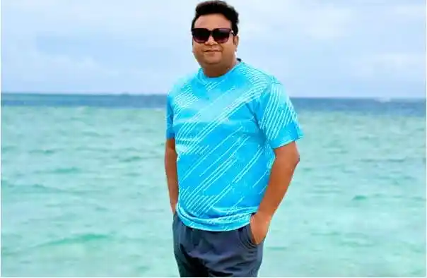 সমুদ্রে দাঁড়িয়ে থাকা ব্যক্তির ছবি, তিনি সানগ্লাস পরেছেন. Channel i News - চ্যানেল আই নিউজ