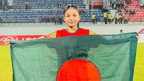 বাংলাদেশ নারী ফুটবল দলের খেলোয়াড় চ্যাম্পিয়নশিপের পর পতাকা ধরে দাঁড়িয়ে. Channel i News - চ্যানেল আই নিউজ