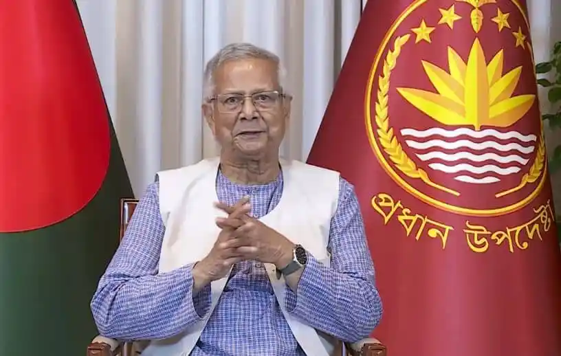 প্রধানমন্ত্রী শেখ হাসিনা জাতীয় পতাকার পাশে বসে আছেন।. Channel i News - চ্যানেল আই নিউজ