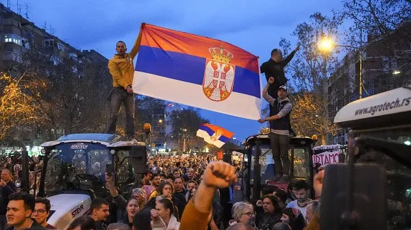 Protesters hold Serbian flag during demonstration in a city street. Channel i News - চ্যানেল আই নিউজ