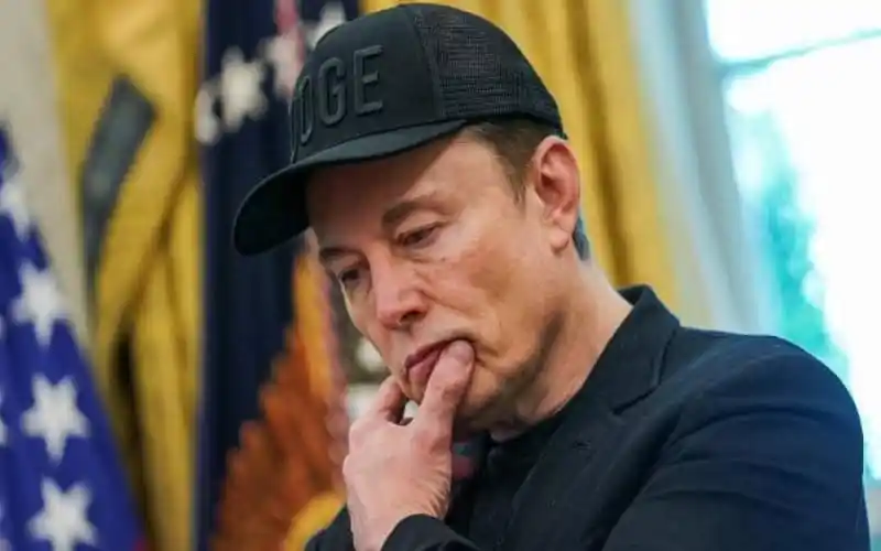 Elon Musk in thoughtful pose during a press conference or event. Channel i News - চ্যানেল আই নিউজ