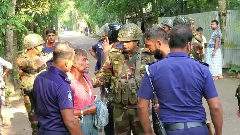 নিহত ব্যক্তির পাশে পুলিশ ও সেনা সদস্যরা দাঁড়িয়ে আছেন. Channel i News - চ্যানেল আই নিউজ