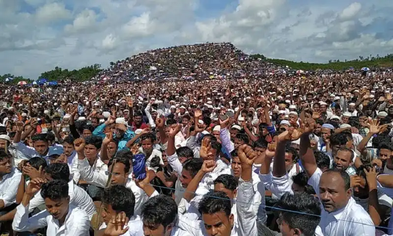 Massive crowd gathered at a rally in Bangladesh with a hill in the background. Channel i News - চ্যানেল আই নিউজ