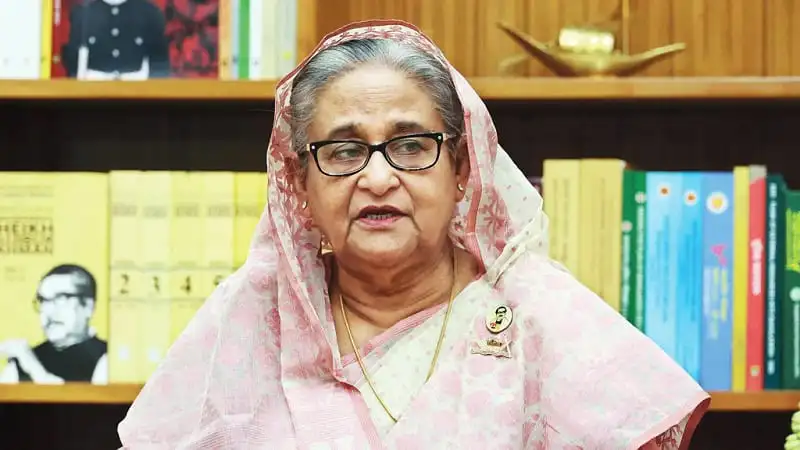 শেখ হাসিনা বইয়ের সামনে দাঁড়িয়ে বক্তৃতা দিচ্ছেন. Channel i News - চ্যানেল আই নিউজ