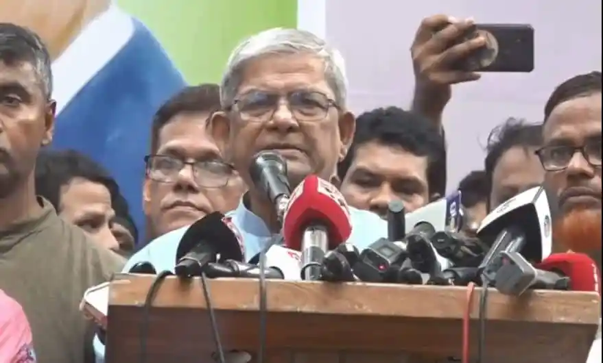 মির্জা ফখরুল ভাষণ দিচ্ছেন, পাশে সমর্থকরা ও মিডিয়া কর্মীরা. Channel i News - চ্যানেল আই নিউজ