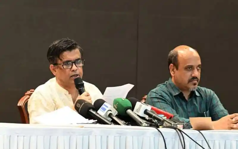 সংবাদ সম্মেলনে দুই কর্মকর্তা, microphones ও নোটবুকের সামনে বসে. Channel i News - চ্যানেল আই নিউজ