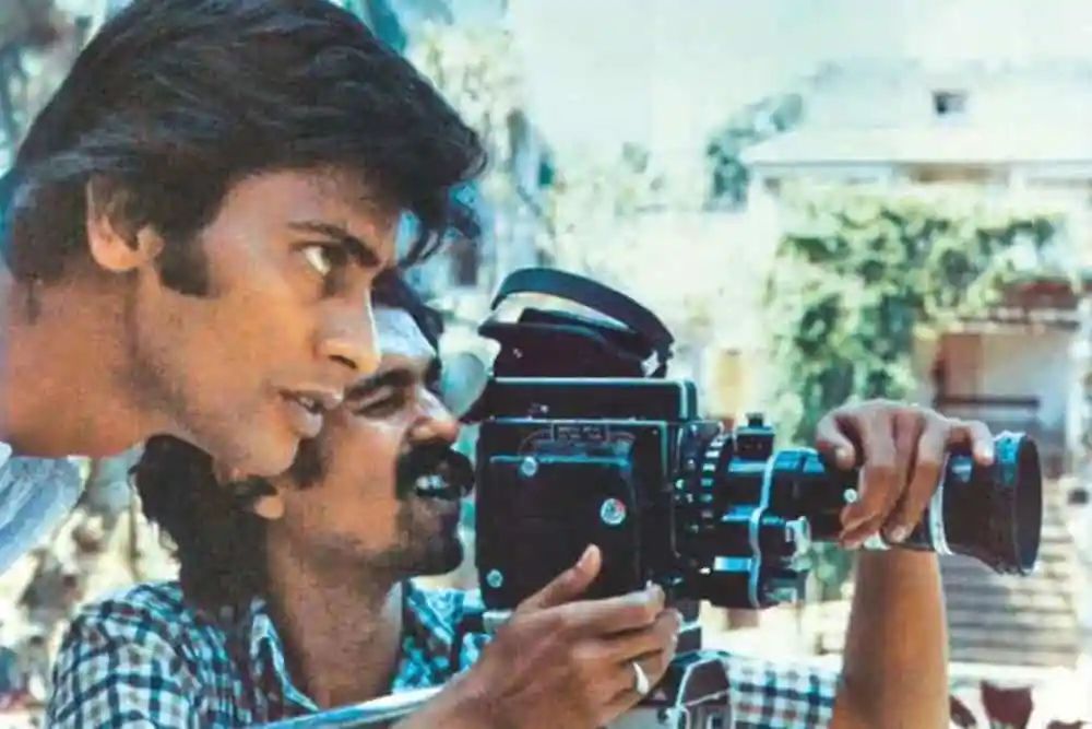 Two men operating a vintage film camera outdoors in Bangladesh. Channel i News - চ্যানেল আই নিউজ