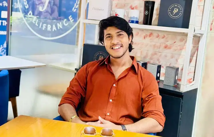 আনন্দিত যুবক হাসিমুখে বসে আছেন ক্যাফে বা রেস্টুরেন্টে. Channel i News - চ্যানেল আই নিউজ