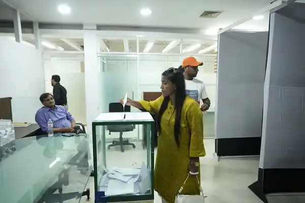 একজন নারী ভোটার ভোট দিচ্ছেন, অন্যরা অপেক্ষা করছেন. Channel i News - চ্যানেল আই নিউজ