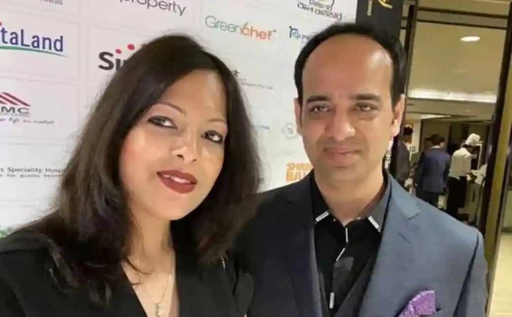 দুটি মানুষ একসঙ্গে ছবি তোলা, পেছনে বিভিন্ন কোম্পানির লোগো দেখা যাচ্ছে. Channel i News - চ্যানেল আই নিউজ