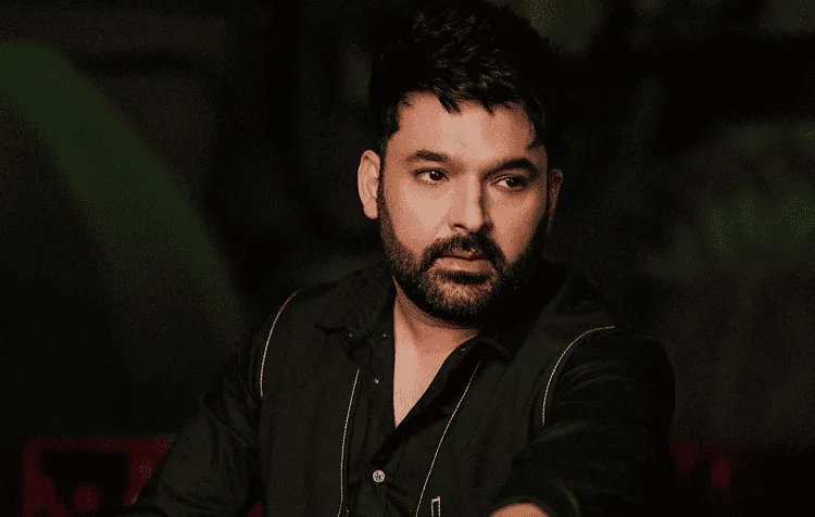 অভিনেতা কপিলের ছবি, তিনি গম্ভীর মুখে তাকিয়ে আছেন।. Channel i News - চ্যানেল আই নিউজ