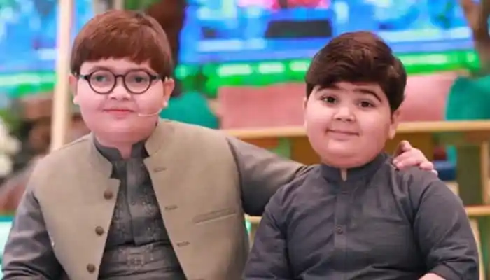 দুই ছোট ভাই একসঙ্গে হাসছে, পেছনে রঙিন সেটের ব্যাকড্রপ।. Channel i News - চ্যানেল আই নিউজ