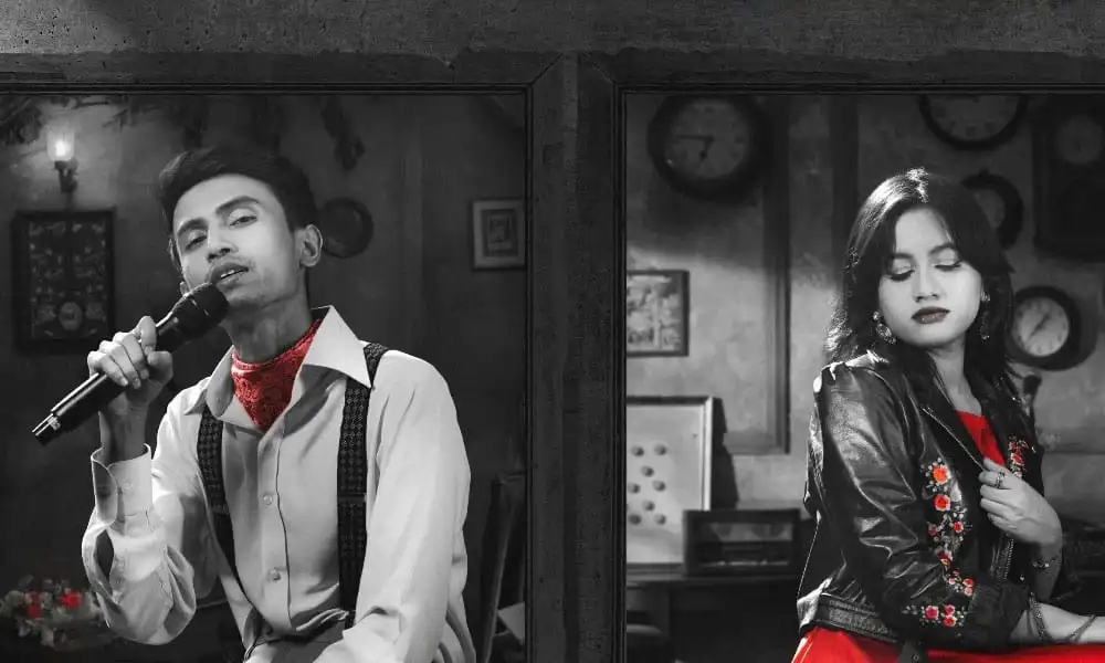 সাদা-কালো ছবি যেখানে একজন পুরুষ গান গাইছেন এবং একজন নারী দাঁড়িয়ে আছেন. Channel i News - চ্যানেল আই নিউজ