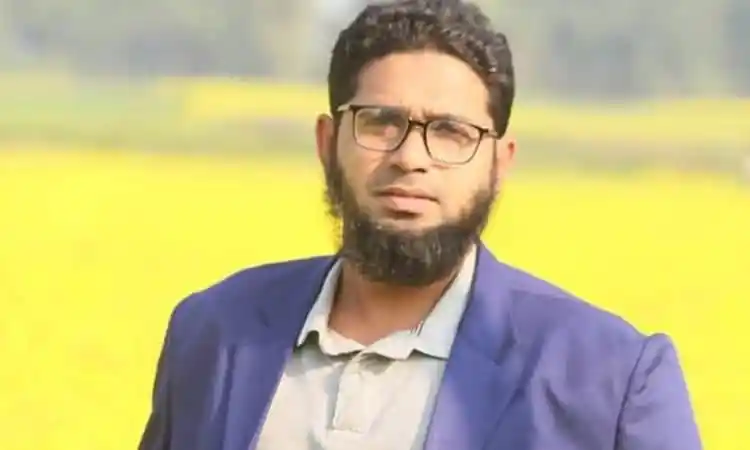 Bangladeshi man with glasses and beard outdoors in a blue blazer. Channel i News - চ্যানেল আই নিউজ