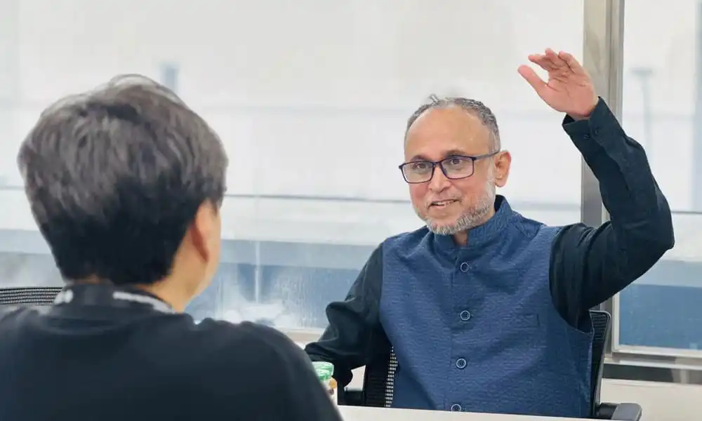 একজন ব্যক্তি অন্যজনের সাথে আলোচনায় অংশ নিচ্ছেন, আলোচনাসভা চলমান. Channel i News - চ্যানেল আই নিউজ