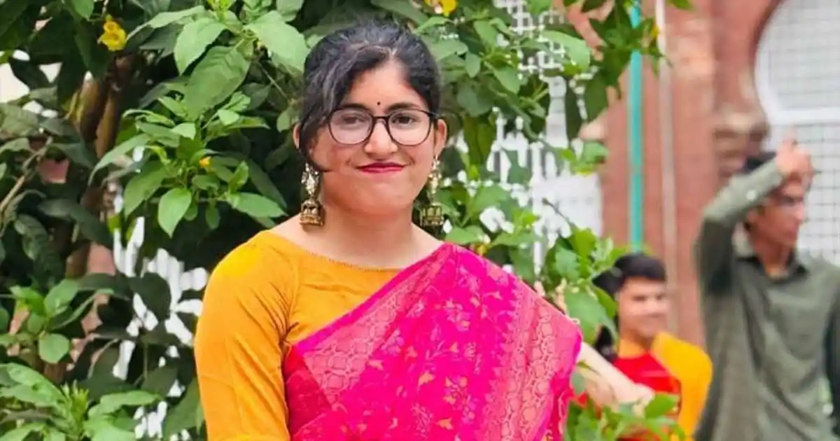 উমামা ফাতেমা হাসিমুখে দাঁড়িয়ে, পটভূমিতে অন্যান্য মানুষ ও গাছ. Channel i News - চ্যানেল আই নিউজ