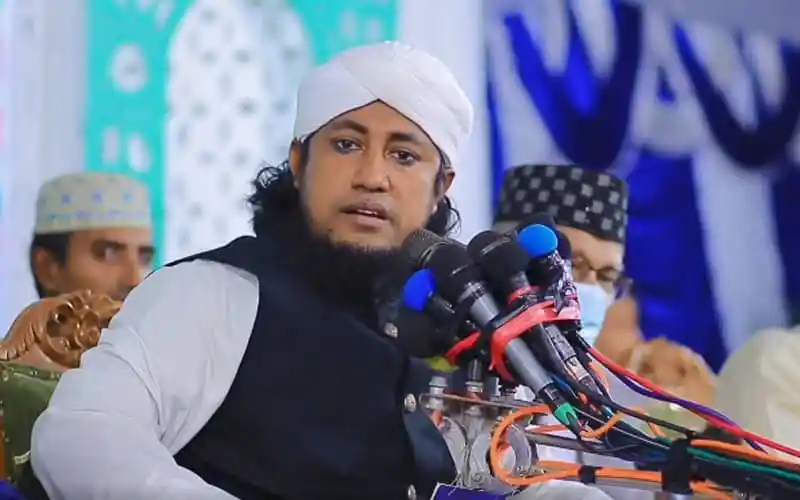 তাহেরী ভাষণ দিচ্ছেন, পেছনে অন্য বক্তারা উপস্থিত. Channel i News - চ্যানেল আই নিউজ