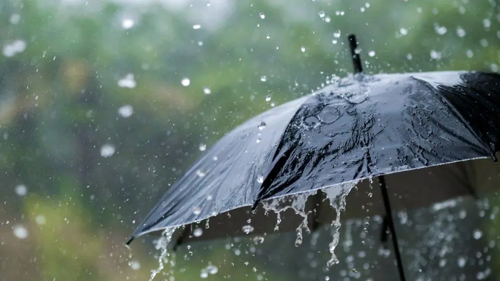 বৃষ্টির মধ্যে ছাতা ধরে থাকা মানুষ, ভারী বর্ষণে জল ঝরছে. Channel i News - চ্যানেল আই নিউজ