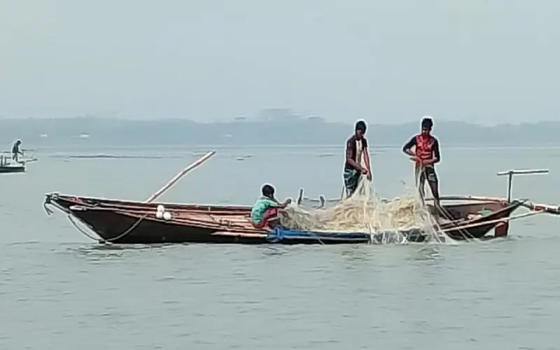 জেলেরা মাছ ধরার জন্য নৌকায় মাছের জাল ছুঁড়ছেন।. Channel i News - চ্যানেল আই নিউজ