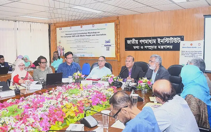 বৈঠকে অংশগ্রহণকারী ব্যক্তিরা আলোচনা করছেন, ফুলের টেবিলের পাশে বসে. Channel i News - চ্যানেল আই নিউজ