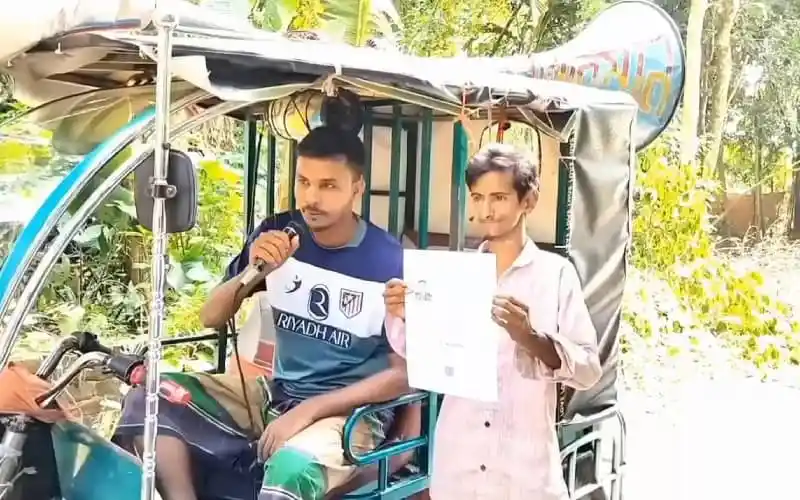 দুই যুবক রিকশায় বসে একটি পত্রিকা দেখাচ্ছেন. Channel i News - চ্যানেল আই নিউজ
