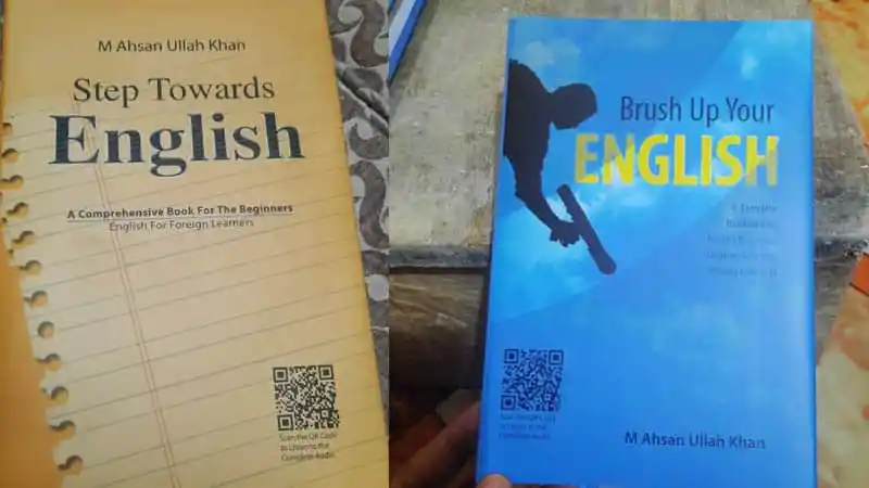 Two English language books for beginners on a wooden surface. Channel i News - চ্যানেল আই নিউজ