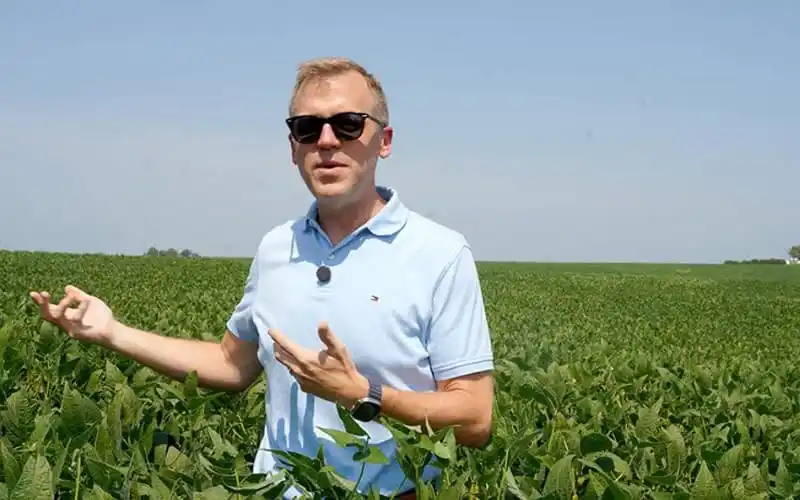 A man in sunglasses standing in a green field under a clear sky. Channel i News - চ্যানেল আই নিউজ