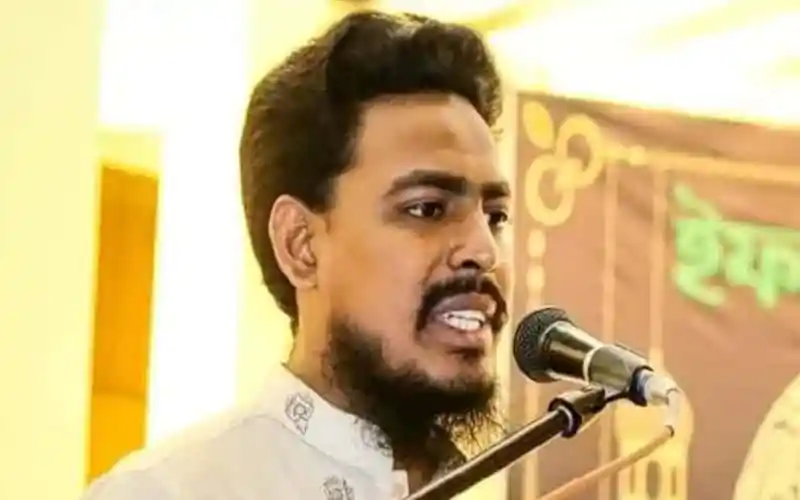 আখতার হোসেন বক্তৃতা দিচ্ছেন, পেছনে বাংলাদেশি পতাকা ও ব্যানার. Channel i News - চ্যানেল আই নিউজ