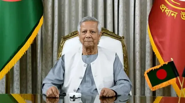 মুহাম্মদ ইউনূসের ছবি, তিনি বসে আছেন, পটভূমিতে বাংলাদেশের পতাকা ও রাষ্ট্রীয় পতাকা।. Channel i News - চ্যানেল আই নিউজ