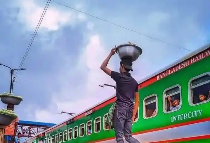 রেলওয়ে স্টেশনে একজন ব্যক্তি ট্রেনে খাবার বা পণ্য বহন করছেন. Channel i News - চ্যানেল আই নিউজ