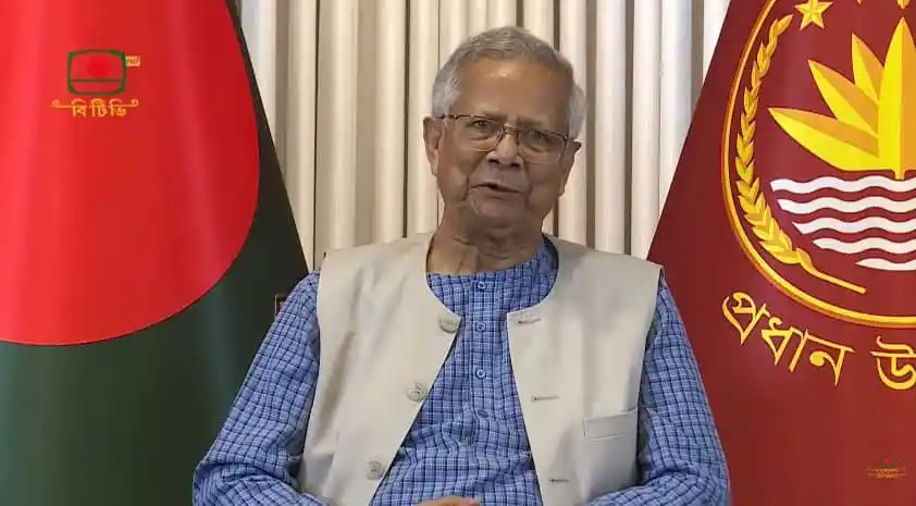 বাংলাদেশের প্রধানমন্ত্রী শেখ হাসিনা জাতীয় পতাকার পাশে বসে আছেন।. Channel i News - চ্যানেল আই নিউজ