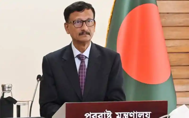 বাংলাদেশের একজন সরকারী কর্মকর্তা, পত্রিকার পেছনে বাংলাদেশের পতাকা।. Channel i News - চ্যানেল আই নিউজ