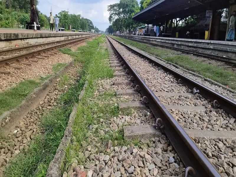 রেললাইনের পাশে ট্রেনের ট্র্যাক, দূরে কিছু মানুষ দাঁড়িয়ে আছে. Channel i News - চ্যানেল আই নিউজ
