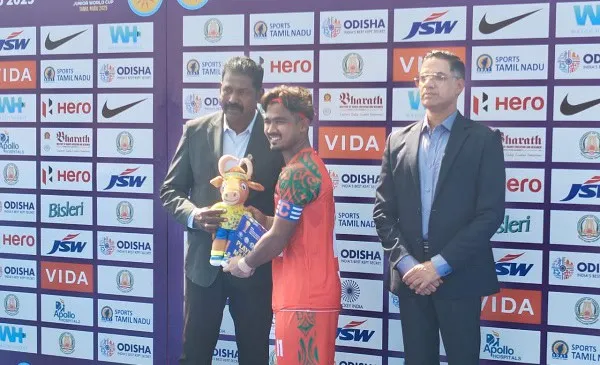 ফুটবল খেলোয়াড়ের পুরস্কার গ্রহণের সময়ের ছবি, পুরস্কার হাতে নিয়ে হাসিমুখে. Channel i News - চ্যানেল আই নিউজ