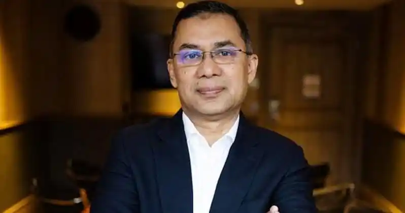 Portrait of a man in formal attire with glasses in an indoor setting. Channel i News - চ্যানেল আই নিউজ