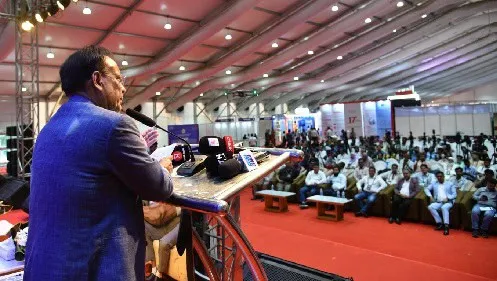 বাংলাদেশের একজন বক্তা জনসম্মুখে বক্তব্য দিচ্ছেন, দর্শকরা শুনছেন।. Channel i News - চ্যানেল আই নিউজ