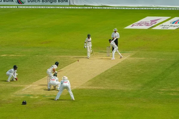 ক্রিকেট খেলোয়াড়রা মাঠে ব্যাটিং করছে, দর্শকরা দেখছেন. Channel i News - চ্যানেল আই নিউজ