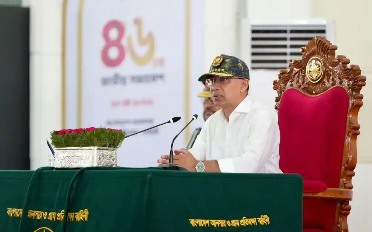 প্রধানমন্ত্রী আনুষ্ঠানিকভাবে বক্তব্য দিচ্ছেন, পেছনে বাংলাদেশ পতাকা. Channel i News - চ্যানেল আই নিউজ
