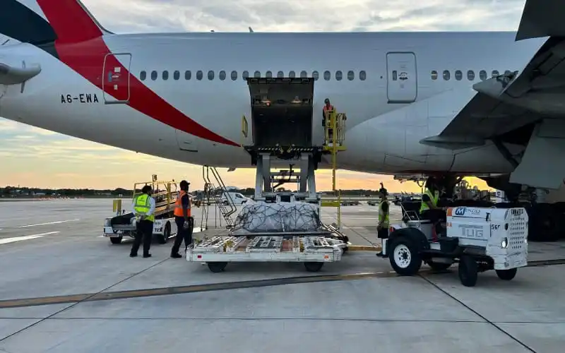 Airplane being loaded with cargo at an airport during sunset. Channel i News - চ্যানেল আই নিউজ
