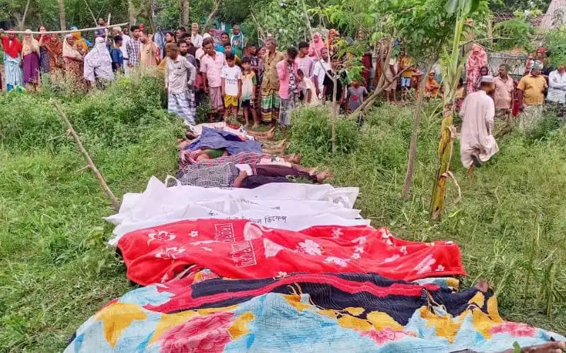 Many clothes and fabrics laid out on the ground with a crowd of people in the background. Channel i News - চ্যানেল আই নিউজ