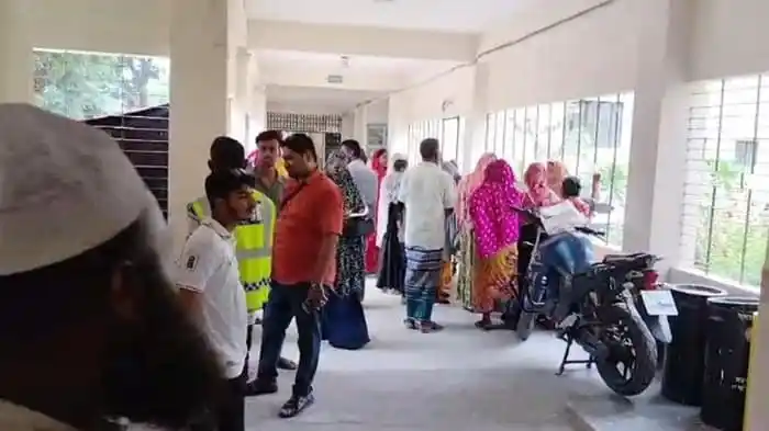 People waiting in line at a Bangladeshi government office or service center. Channel i News - চ্যানেল আই নিউজ