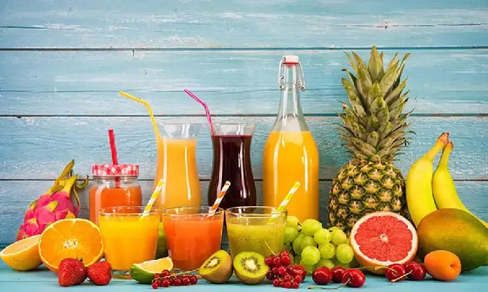 Fresh fruit juices and fruits on a blue wooden background. Channel i News - চ্যানেল আই নিউজ