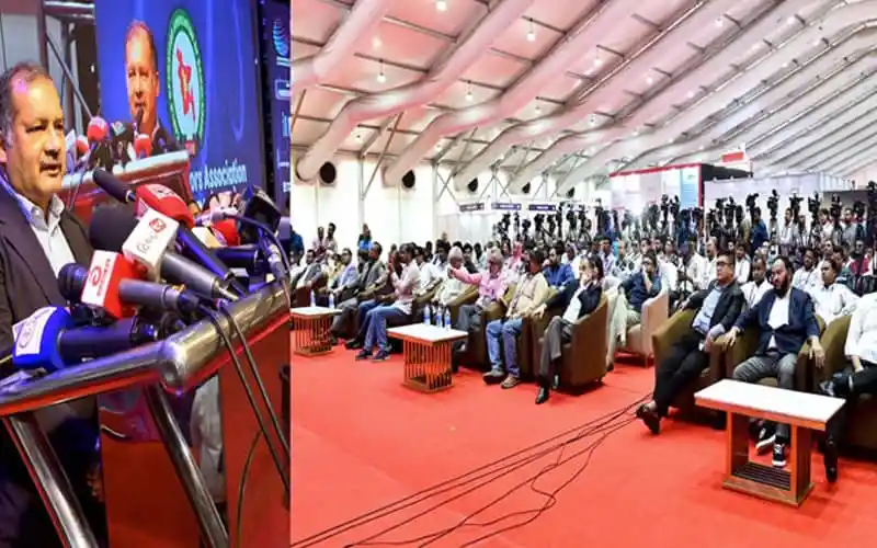 TDM Minister speaking at a press conference with a large audience present. Channel i News - চ্যানেল আই নিউজ
