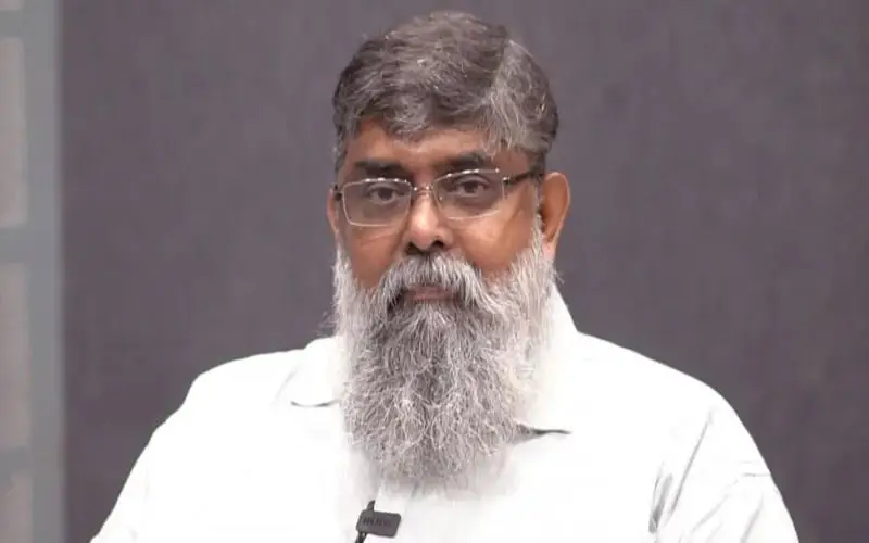 বয়সী পুরুষের ছবি, গোঁফ ও দাড়ি বিশিষ্ট, চশমা পরা, সাদা শার্ট পরিহিত. Channel i News - চ্যানেল আই নিউজ