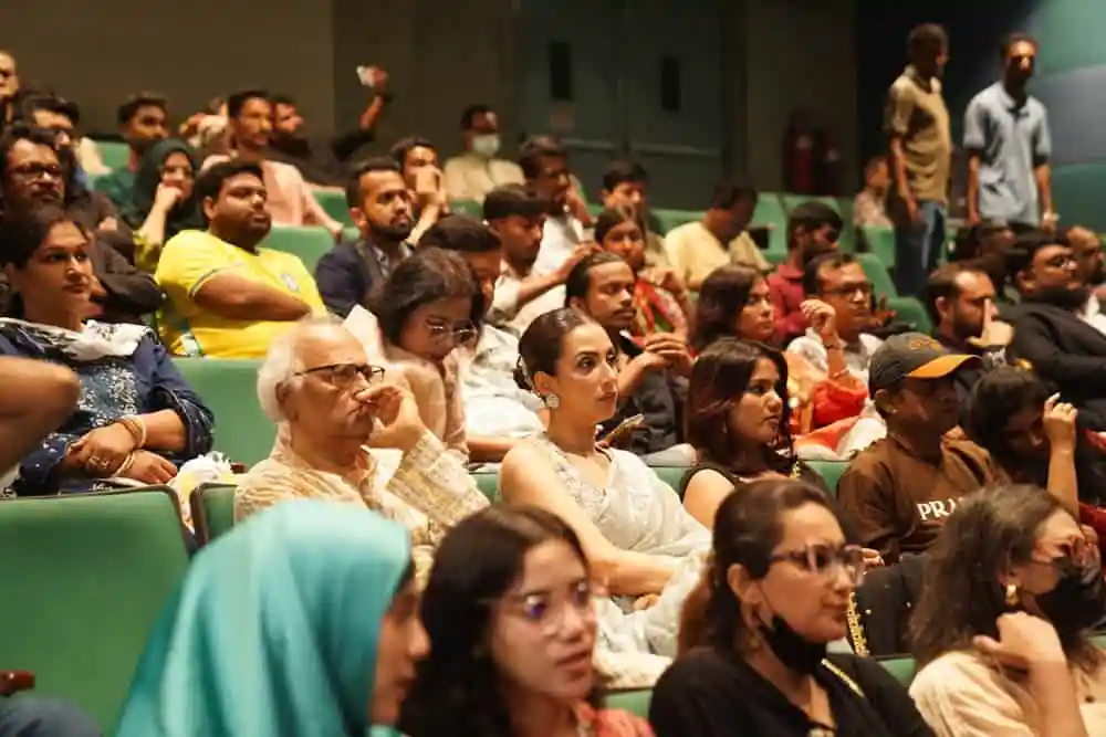 Bangladeshi audience attentively watching a live event in an auditorium. Channel i News - চ্যানেল আই নিউজ