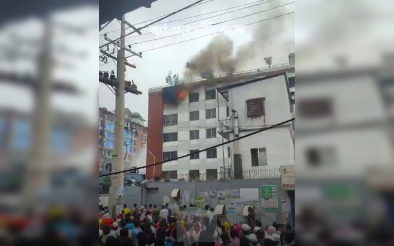 Building fire with smoke rising in Dhaka, Bangladesh, during daytime. Channel i News - চ্যানেল আই নিউজ