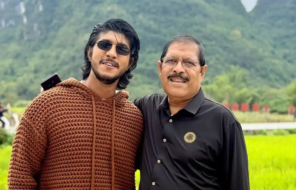 দুই পুরুষ হাসিমুখে একসঙ্গে ছবি তুলছেন, প্রাকৃতিক পটভূমিতে. Channel i News - চ্যানেল আই নিউজ