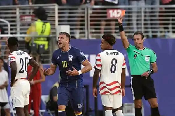 Football player receiving red card during match with referee showing card. Channel i News - চ্যানেল আই নিউজ