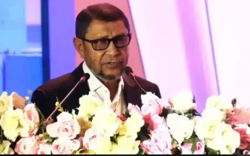 স্বাস্থ্যমন্ত্রী টেন্ডার বিষয়ক আলোচনা করছেন, ফুলের সামনে দাঁড়িয়ে. Channel i News - চ্যানেল আই নিউজ